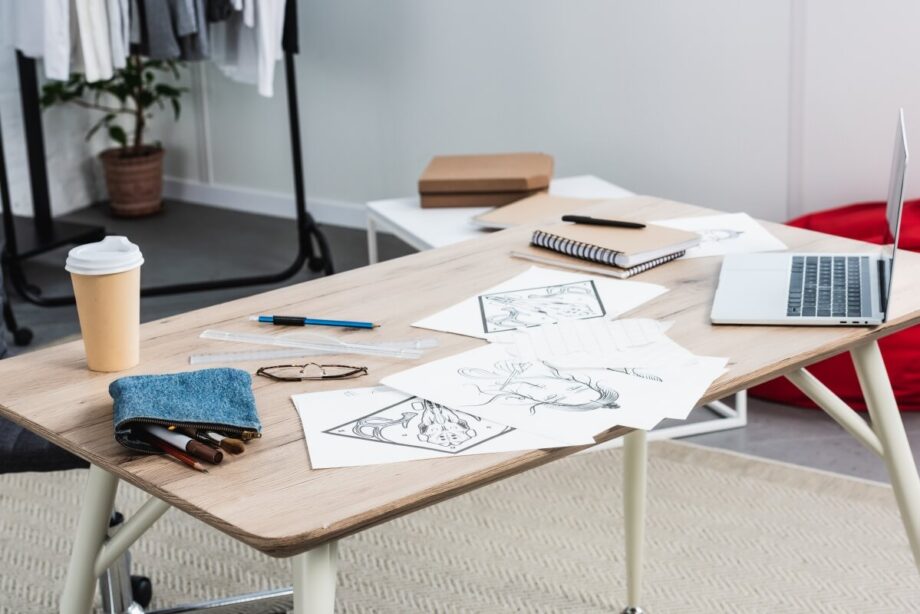 Na biurku z laptopem i notatkami znajdują się składane stelaże do stołu.