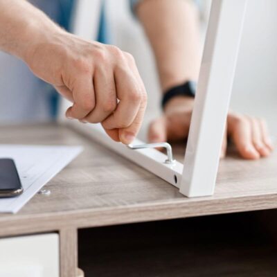 Mężczyzna montuje stelaze meblowe przy użyciu klucza sześciokątnego.