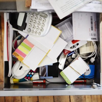 Otwarta, zapełniona przedmiotami szuflada stalowa w biurze.